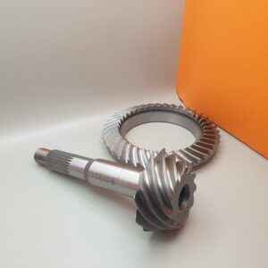 The Import placeholder for 1942, a steel ring gear and pinion with spiral-cut teeth, is shown on a light surface against an orange background, with the pinion positioned in front of the ring gear.